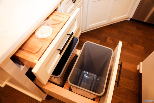 interior details featuring dark wood-type flooring and white cabinets