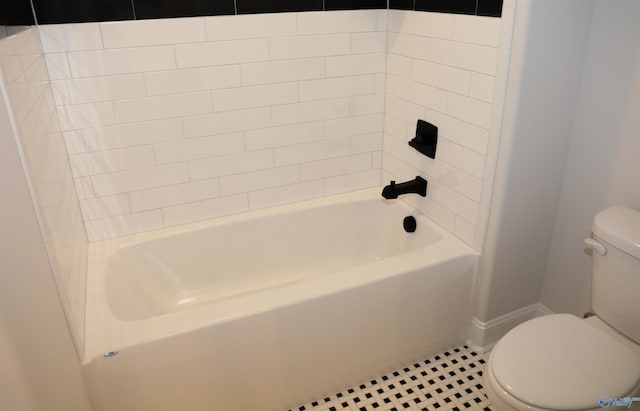 bathroom with washtub / shower combination, tile patterned flooring, and toilet