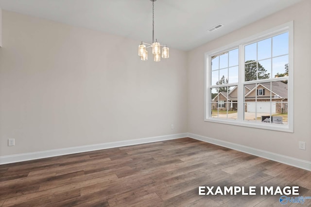 unfurnished dining area featuring wood-type flooring and an inviting chandelier