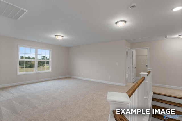 spare room featuring light colored carpet