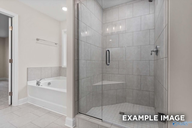 bathroom with separate shower and tub and tile patterned flooring