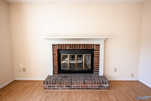 room details with a brick fireplace, baseboards, and wood finished floors