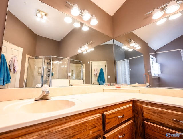 bathroom featuring lofted ceiling, a shower stall, and vanity