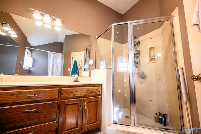 bathroom with lofted ceiling, a stall shower, and vanity