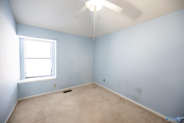 carpeted spare room with ceiling fan, visible vents, and baseboards