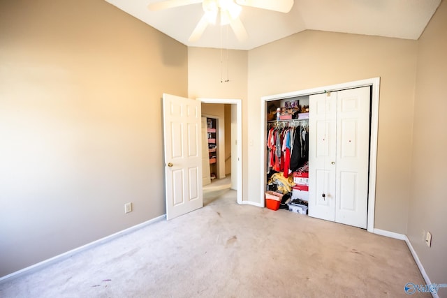 unfurnished bedroom with carpet, a closet, vaulted ceiling, and baseboards