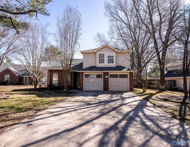 traditional-style home with aphalt driveway, brick siding, and an attached garage