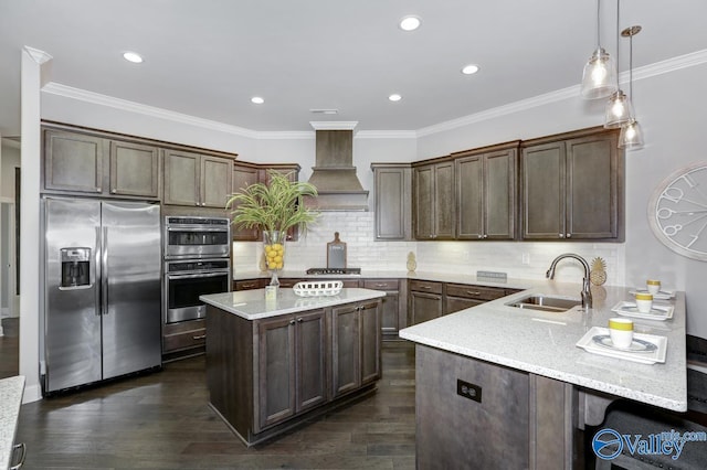 kitchen with sink, premium range hood, appliances with stainless steel finishes, light stone countertops, and kitchen peninsula