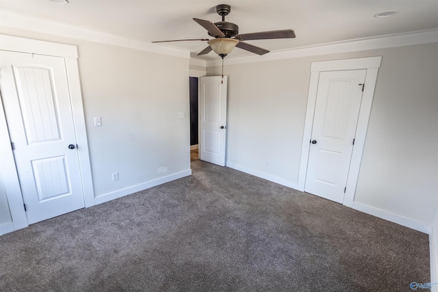 unfurnished bedroom with dark colored carpet, ceiling fan, and crown molding