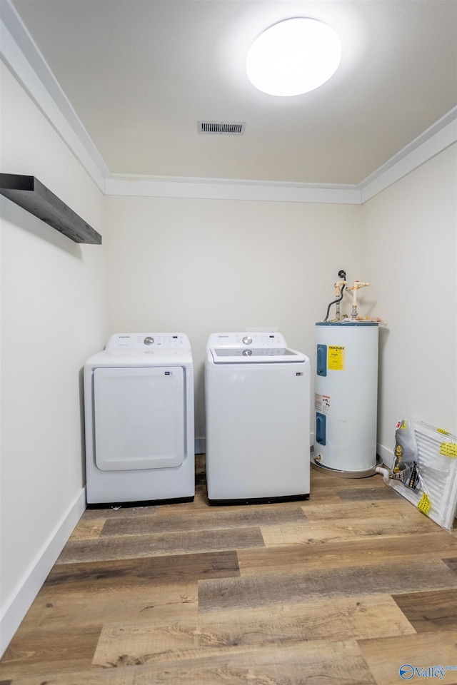 laundry room with electric water heater, crown molding, washer and dryer, and hardwood / wood-style floors