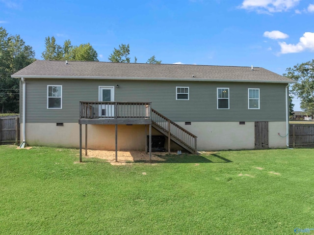 rear view of house featuring a deck and a lawn