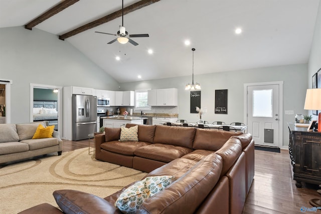 living room featuring hardwood / wood-style flooring, beamed ceiling, plenty of natural light, and ceiling fan with notable chandelier