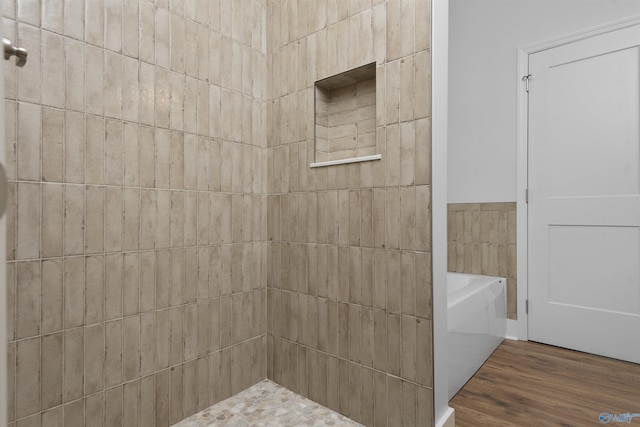 bathroom featuring wood-type flooring and a bath