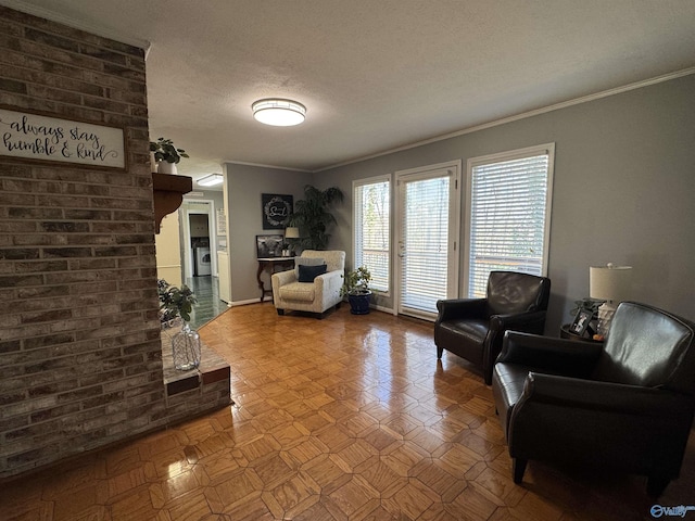 living area featuring ornamental molding, a textured ceiling, and brick wall