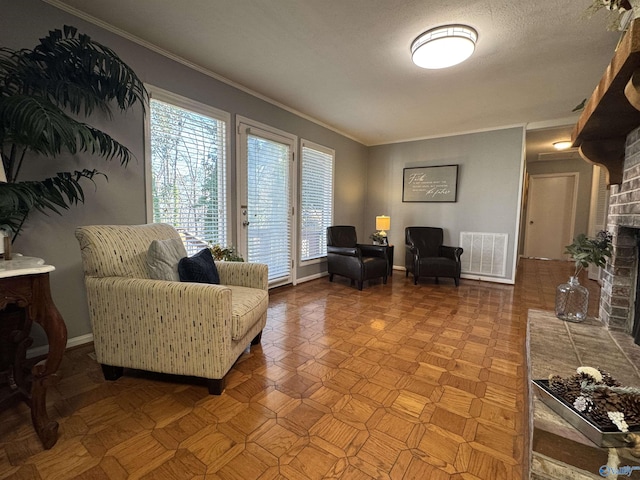 sitting room with ornamental molding, a fireplace, visible vents, and baseboards