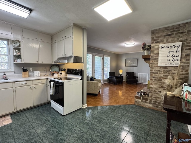 kitchen featuring a wealth of natural light, range with electric cooktop, light countertops, and under cabinet range hood