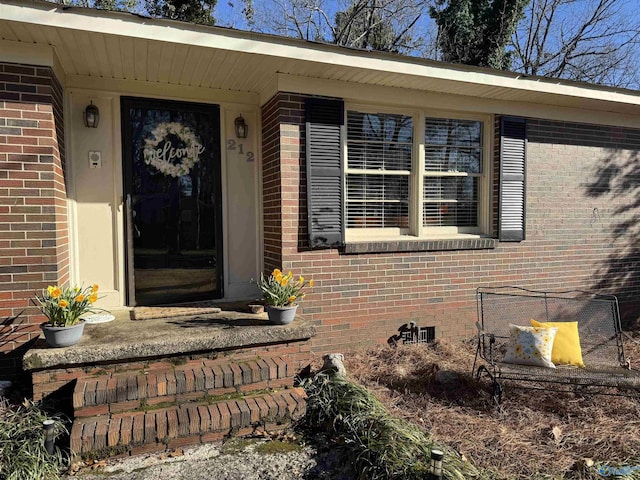 entrance to property with crawl space and brick siding