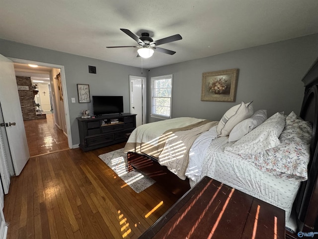 bedroom featuring dark wood-style flooring, a ceiling fan, and baseboards