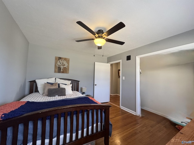 bedroom with visible vents, ceiling fan, a textured ceiling, wood finished floors, and baseboards