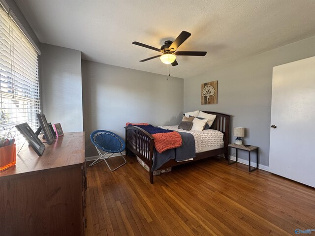 bedroom featuring ceiling fan, dark wood finished floors, and baseboards