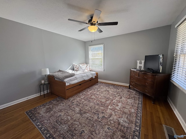 bedroom featuring dark wood finished floors, visible vents, and baseboards