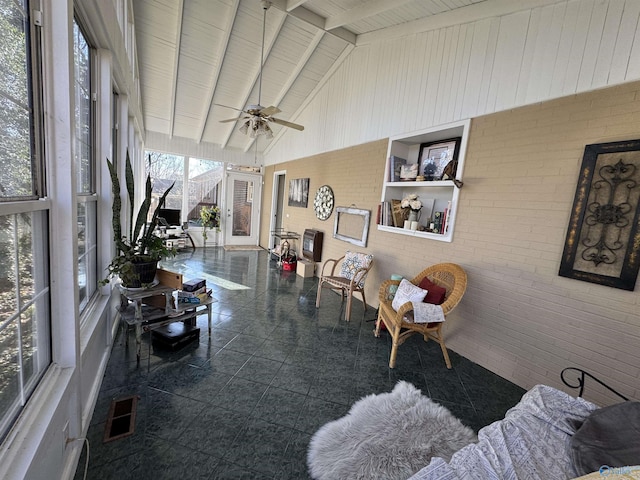 sunroom featuring vaulted ceiling with beams, ceiling fan, and visible vents