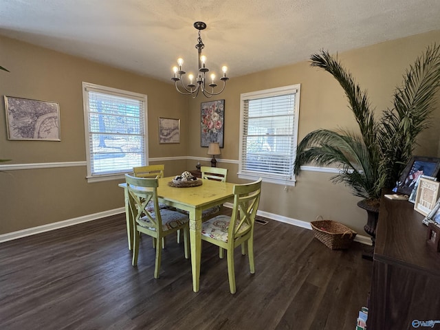 dining area featuring an inviting chandelier, baseboards, and wood finished floors