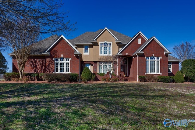 traditional-style home featuring brick siding and a front yard