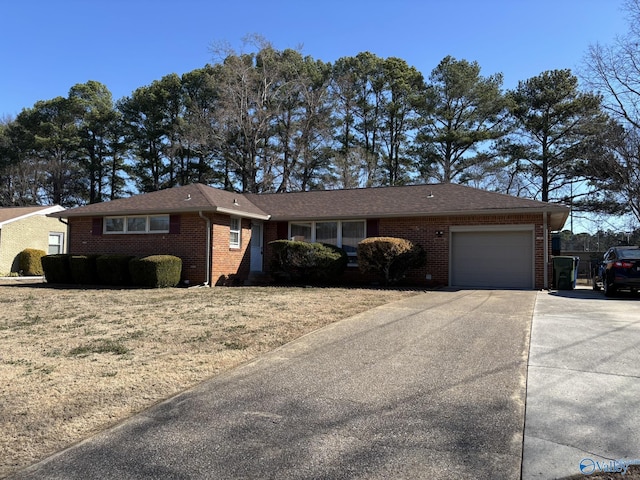 single story home featuring an attached garage, driveway, and brick siding