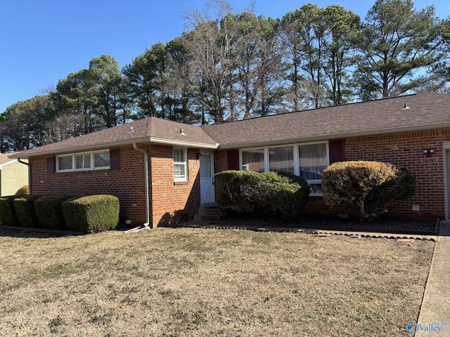 ranch-style house featuring a front yard, brick siding, and roof with shingles