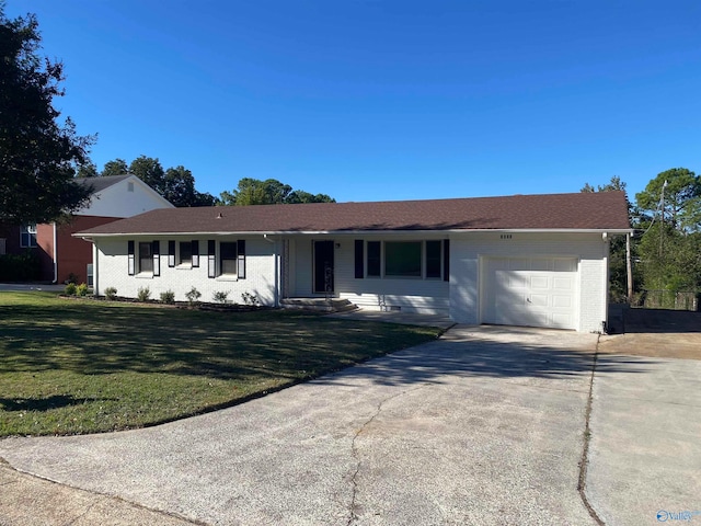 ranch-style house featuring a garage and a front lawn