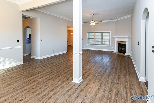 unfurnished living room with crown molding, dark wood-type flooring, and ceiling fan