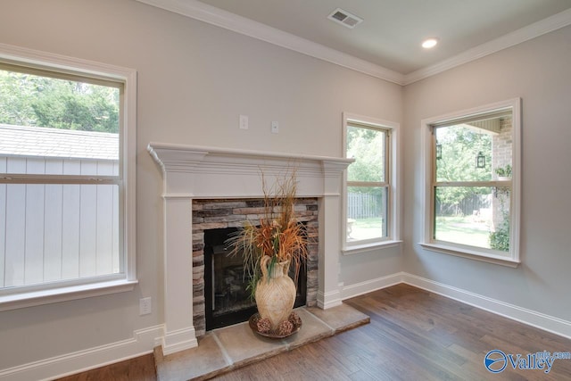 unfurnished living room with a stone fireplace, hardwood / wood-style floors, and crown molding