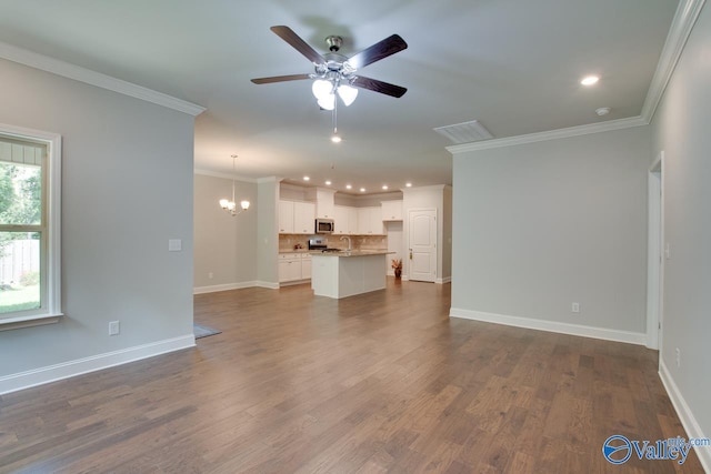 unfurnished living room featuring hardwood / wood-style floors, ceiling fan with notable chandelier, sink, and ornamental molding