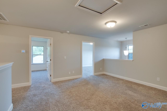 spare room with a wealth of natural light and light colored carpet