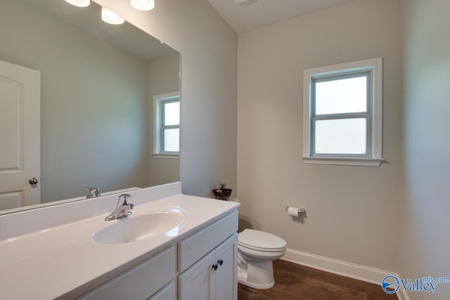 bathroom featuring toilet, vanity, and hardwood / wood-style flooring