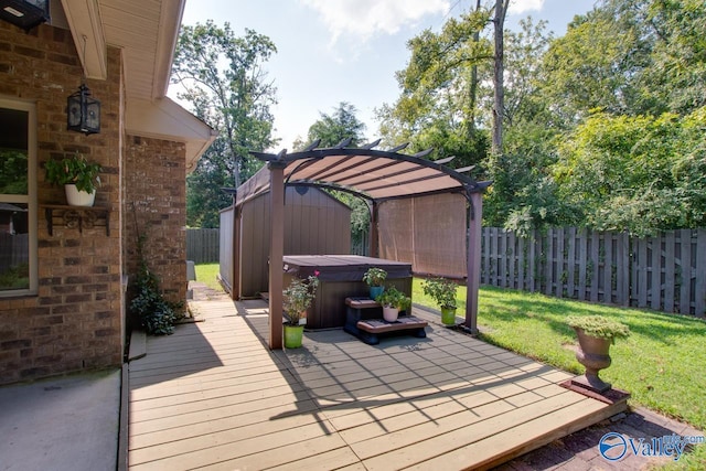 deck featuring a hot tub, a pergola, and a lawn