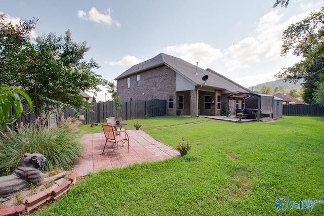 rear view of property with a lawn and a patio