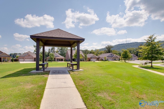 view of property's community featuring a garage, a yard, and a gazebo