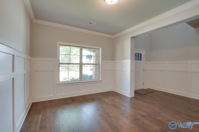 spare room featuring dark hardwood / wood-style flooring and crown molding