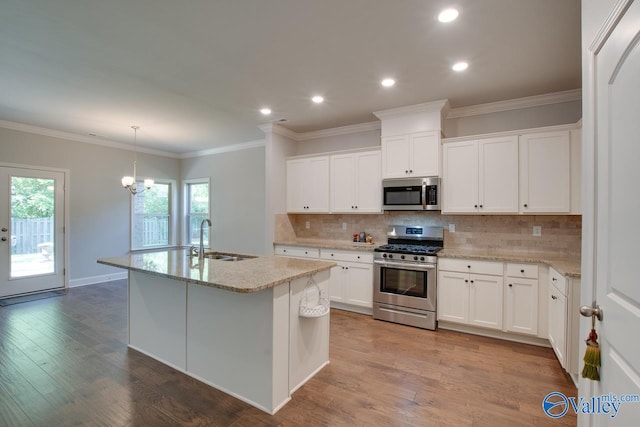 kitchen with a center island with sink, stainless steel appliances, white cabinetry, light wood-type flooring, and sink