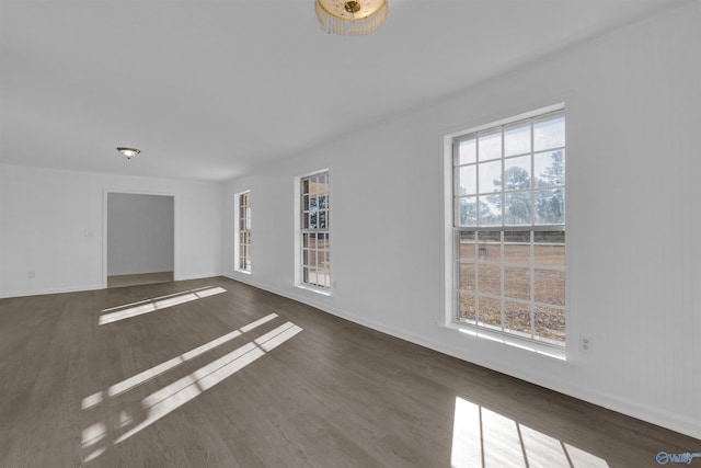 unfurnished room with a wealth of natural light, baseboards, and wood finished floors