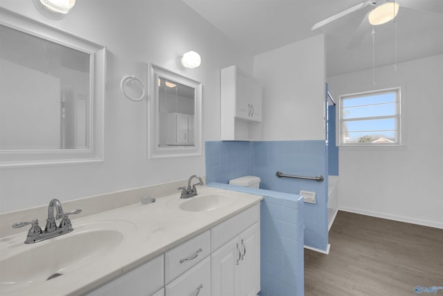 bathroom with double vanity, ceiling fan, a sink, and wood finished floors