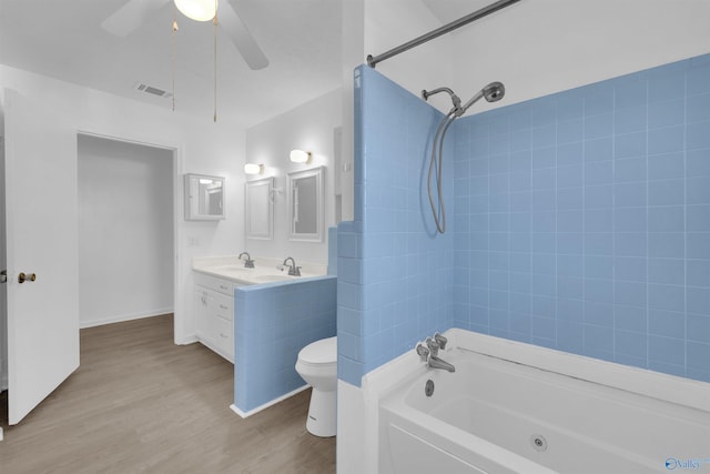 bathroom featuring toilet, wood finished floors, bathing tub / shower combination, visible vents, and double vanity