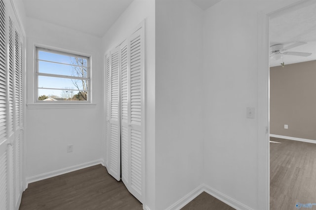 unfurnished bedroom with dark wood-style floors, a closet, and baseboards