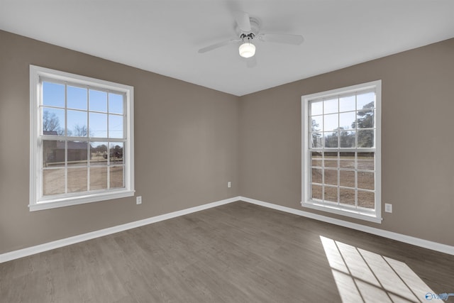 unfurnished room featuring wood finished floors, a ceiling fan, and baseboards