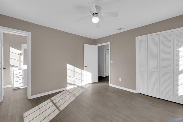 unfurnished bedroom featuring ceiling fan, a closet, baseboards, and wood finished floors