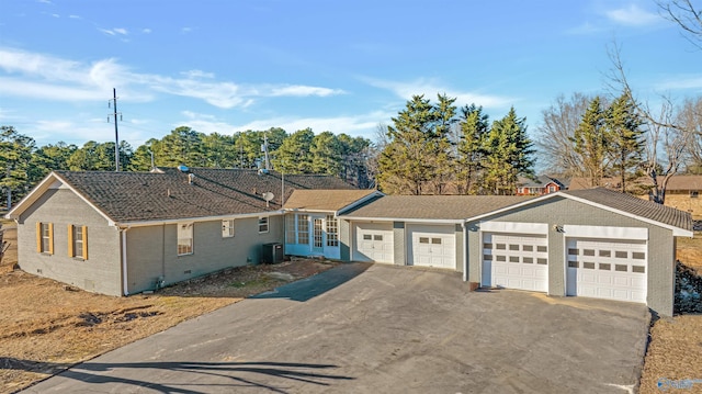 single story home featuring brick siding, central AC unit, crawl space, a garage, and driveway