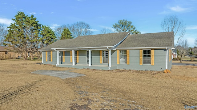 single story home with crawl space, covered porch, roof with shingles, and brick siding