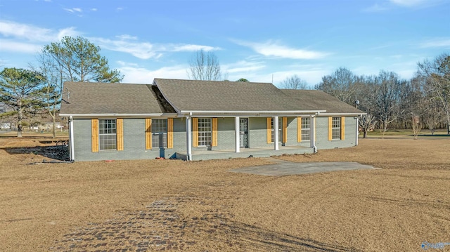 ranch-style home featuring brick siding, roof with shingles, and a porch